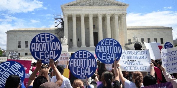 Protesters holding Keep Abortion Legal signs in front of the U.S. Supreme Court building during a demonstration.